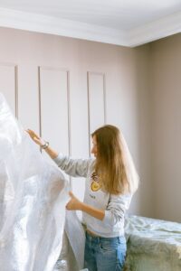 A woman wrapping furniture in bubble wrap